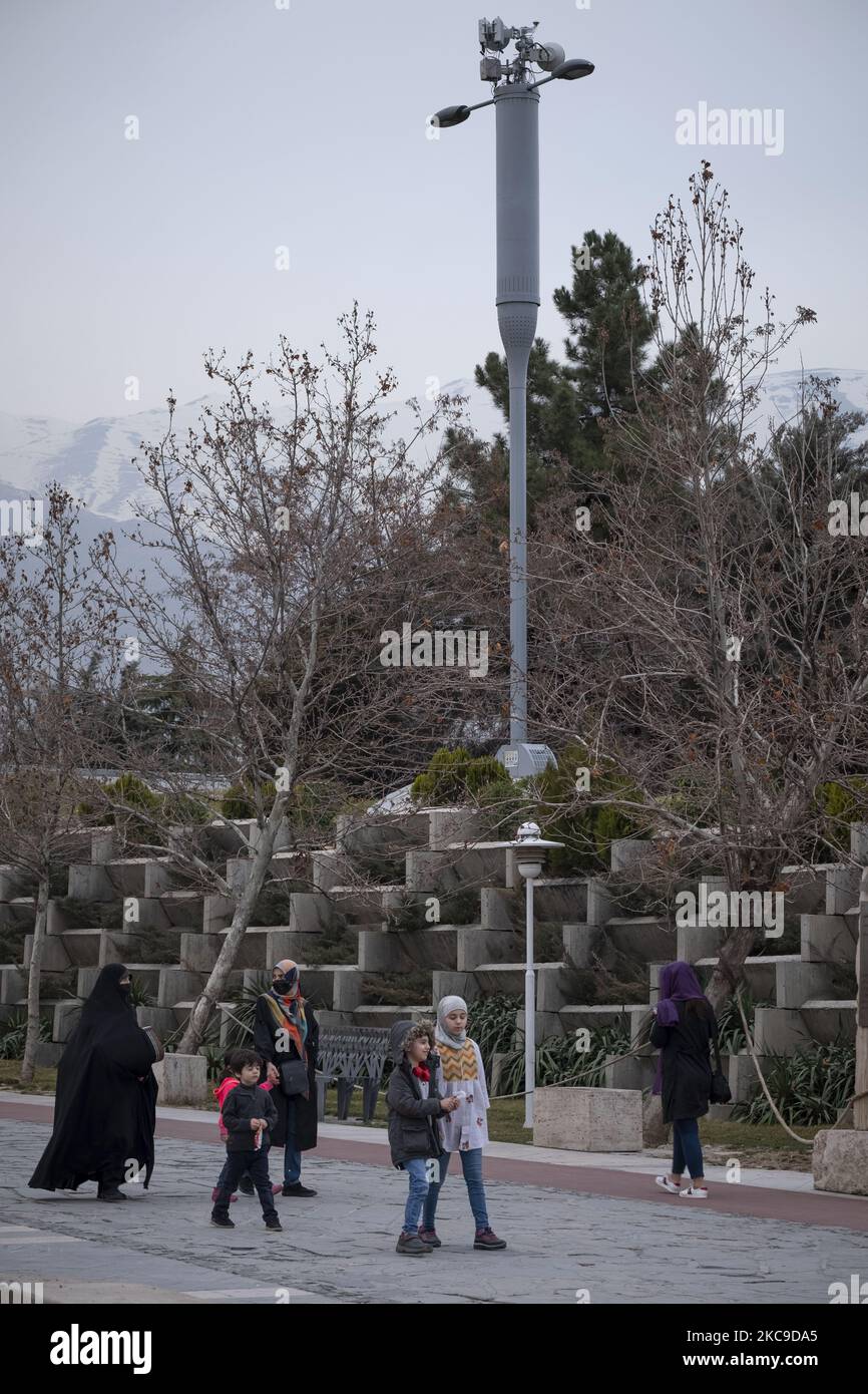Iranian families walk past 5G equipment on a MTN