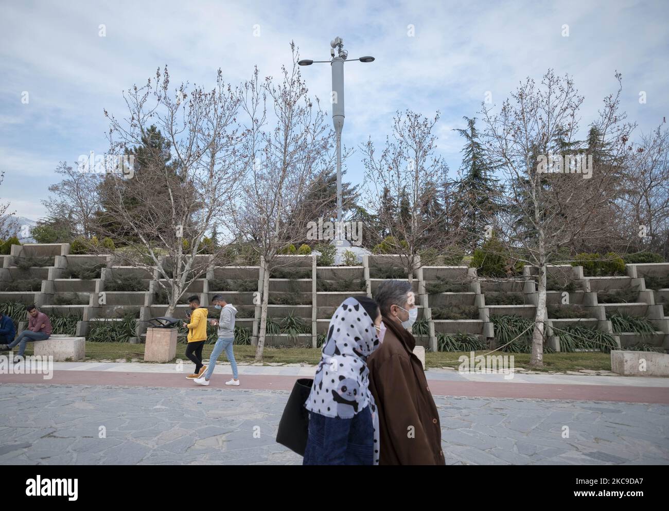 Iranian people walk past 5G equipment on a MTN