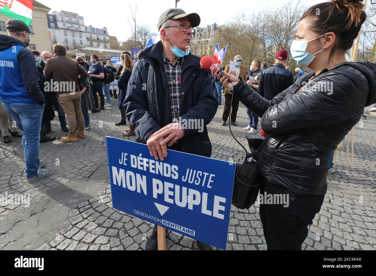 A member of far right group Generation Identitaire (GI) holds a placard reading « I’m just defending my people » speaks with the press during a protest against its potential dissolution in Place Denfert Rochereau, in Paris on February 20, 2021. The dissolution of Generation identitaire was evoked for the first time on January 26, 2021 by Interior Minister, as a reaction to the group's recent anti-migrant operation in the Pyrenees, which led to a preliminary investigation for provocation to racial hatred. (Photo by Michel Stoupak/NurPhoto) Stock Photo