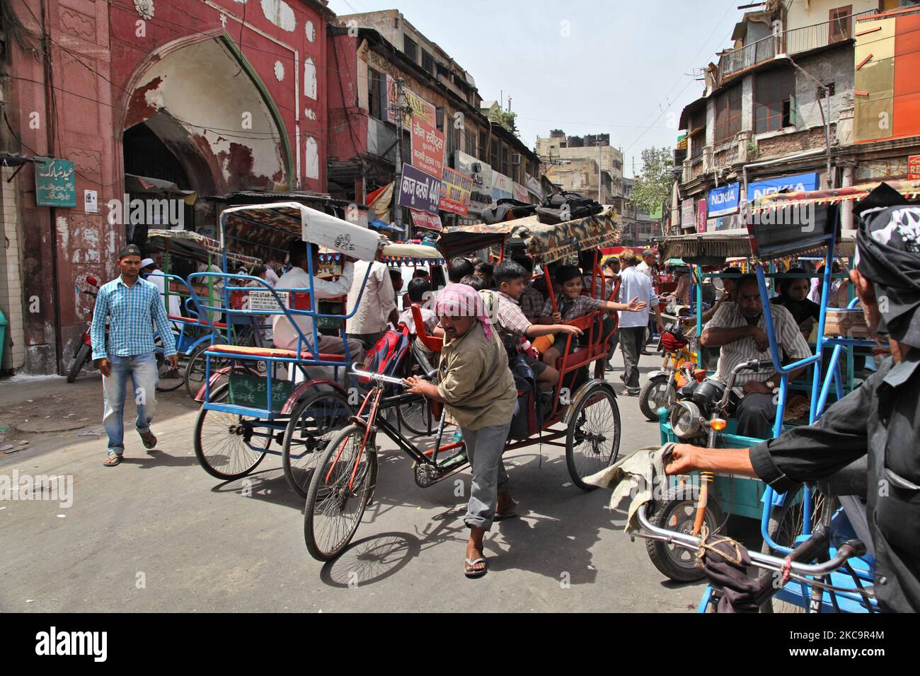 School children travel in an overload rickshaw along a busy street in the Chandni Chowk Market in Old Delhi, India. Chandni Chowk is Asia's largest wholesale market. Legend has it that Mughal emperor Shah Jahan planned Chandni Chowk in the 17th century so that his daughter could shop for all that she wanted. Chandni Chowk, meaning moonlit square or market remains one of the city's most crowded, chaotic and famous areas. (Photo by Creative Touch Imaging Ltd./NurPhoto) Stock Photo