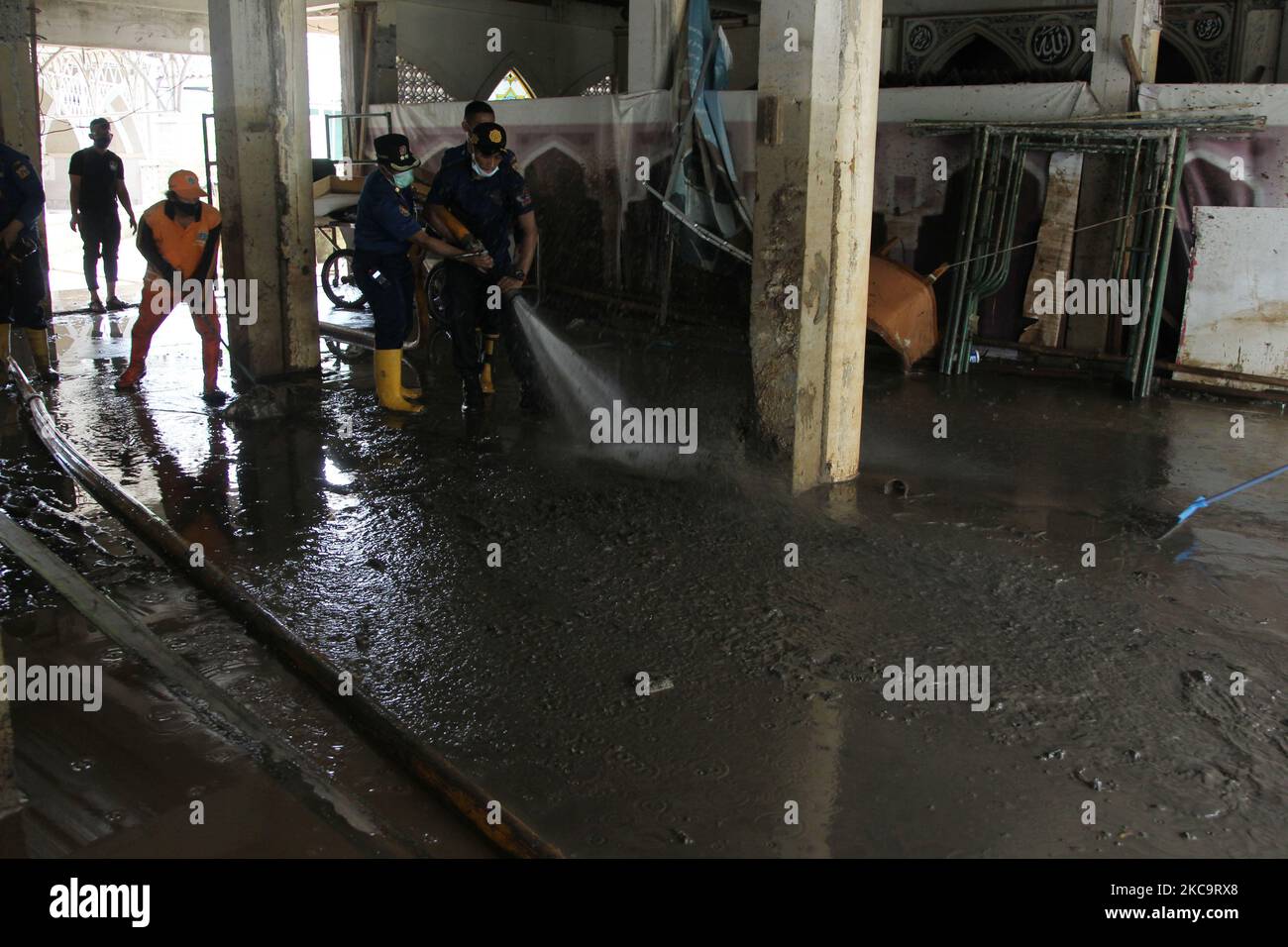 Officers clean up a house of worship (Mosque) in a residential area hit by two meter flood in Cipinang Melayu, Jakarta, on February 22,2021. (Photo by Dasril Roszandi/NurPhoto) Stock Photo