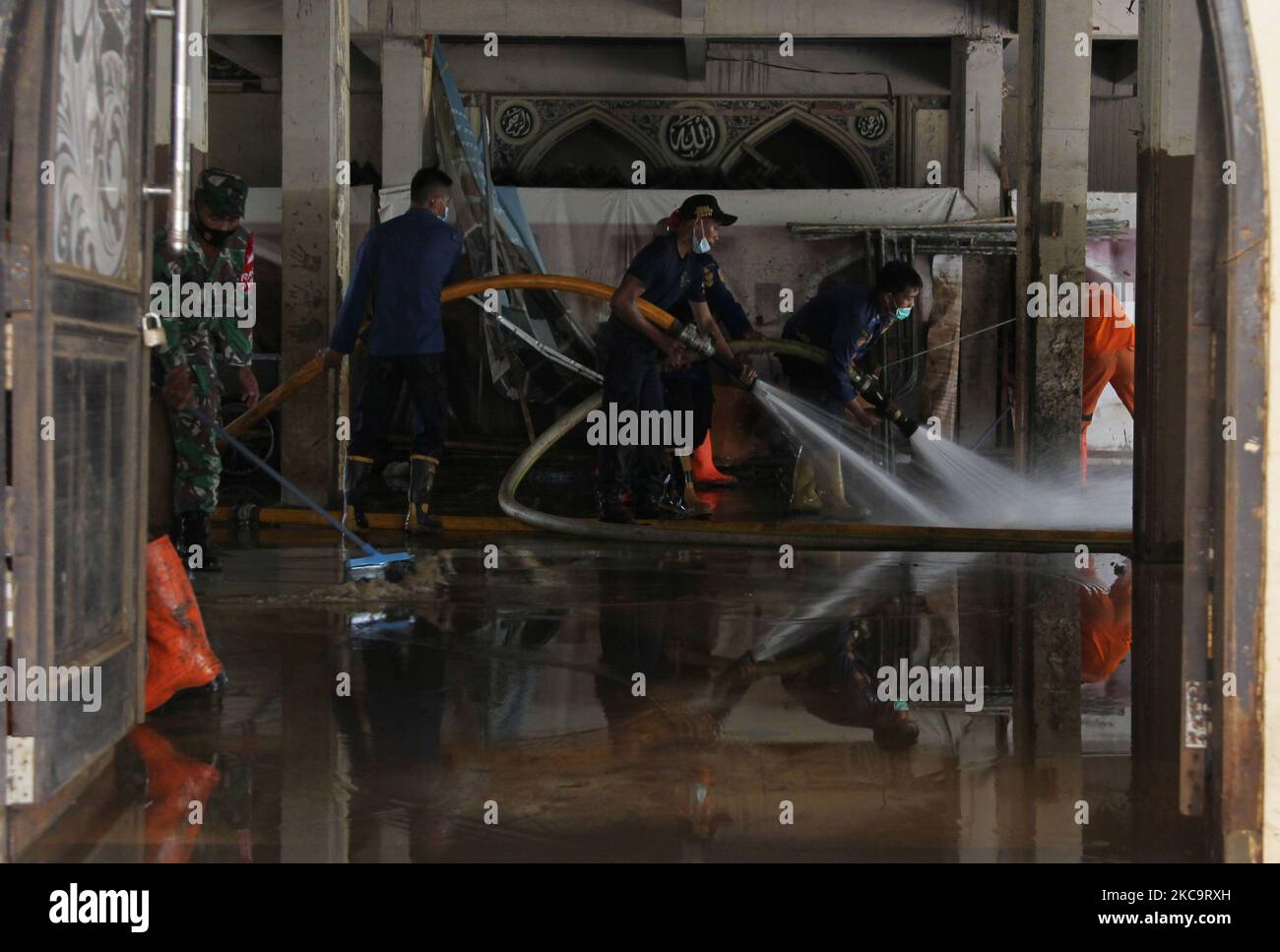 Officers clean up a house of worship (Mosque) in a residential area hit by two meter flood in Cipinang Melayu, Jakarta, on February 22,2021. (Photo by Dasril Roszandi/NurPhoto) Stock Photo