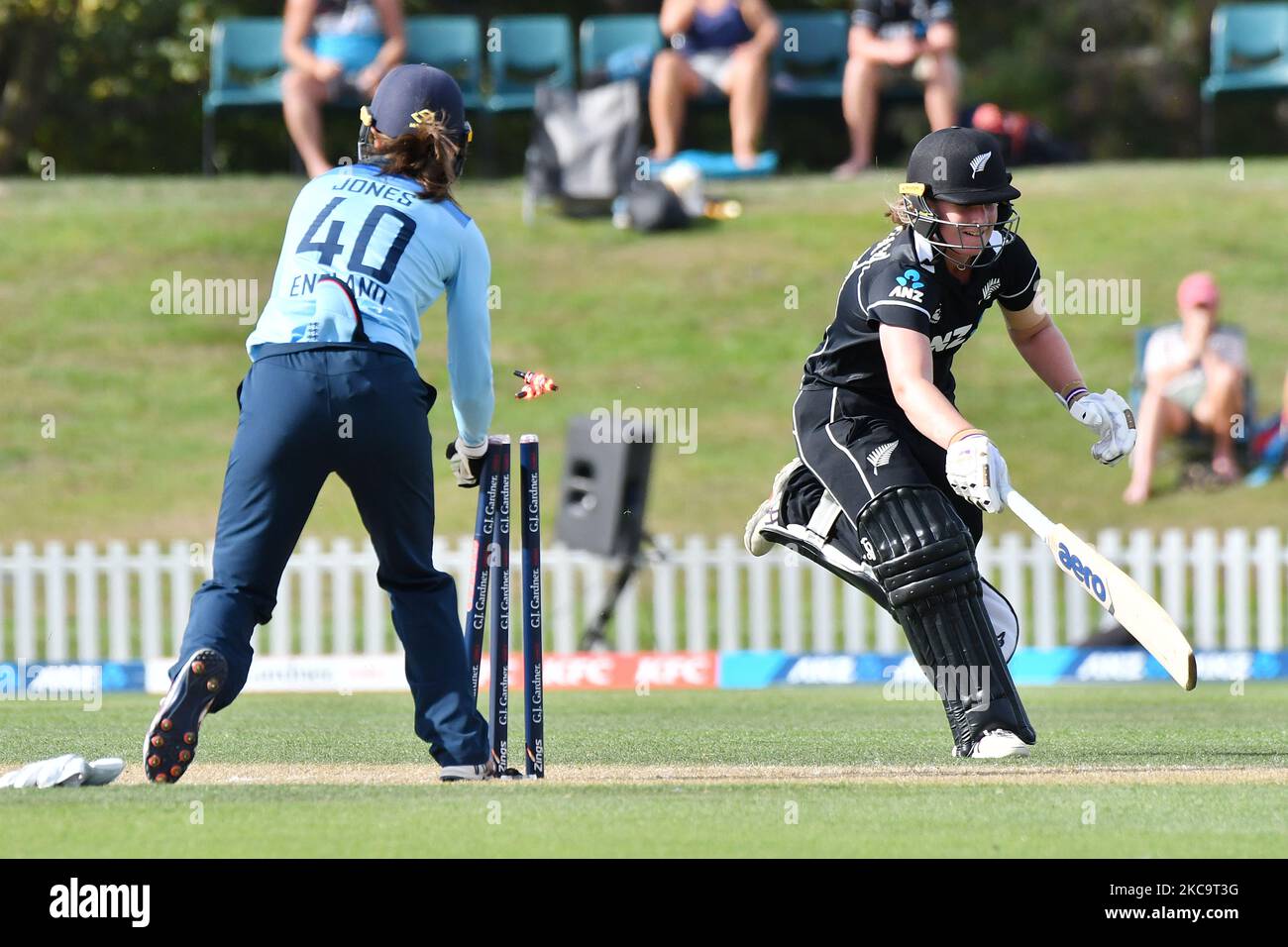 Englandâ€™s wicket keeper Amy Jones (L) successfully removes the bails to dismiss New Zealandâ