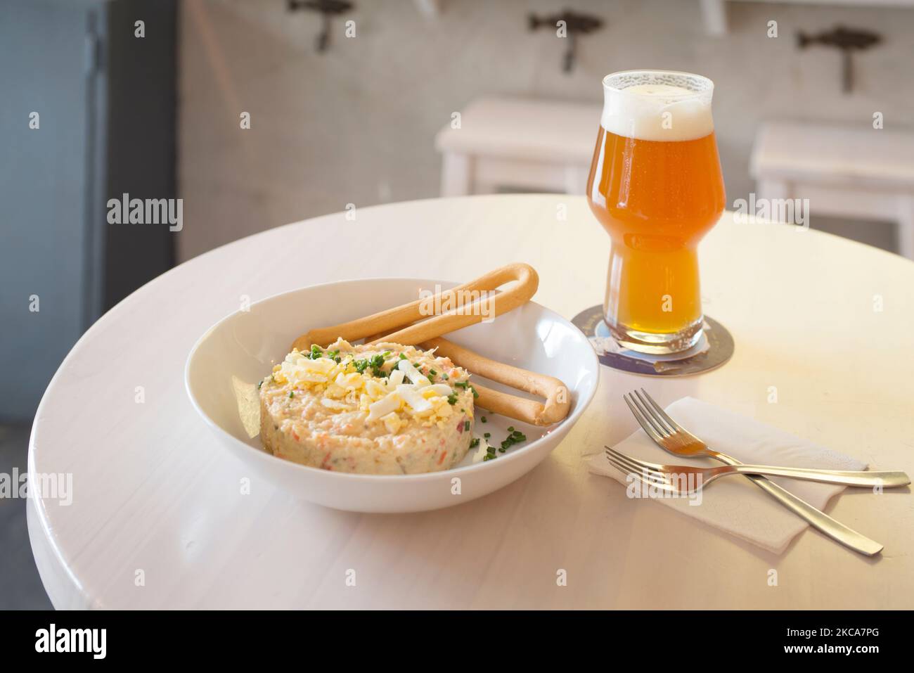 Typical Spanish tapa of Russian salad with boiled egg, dry bread sticks and a glass of beer Stock Photo