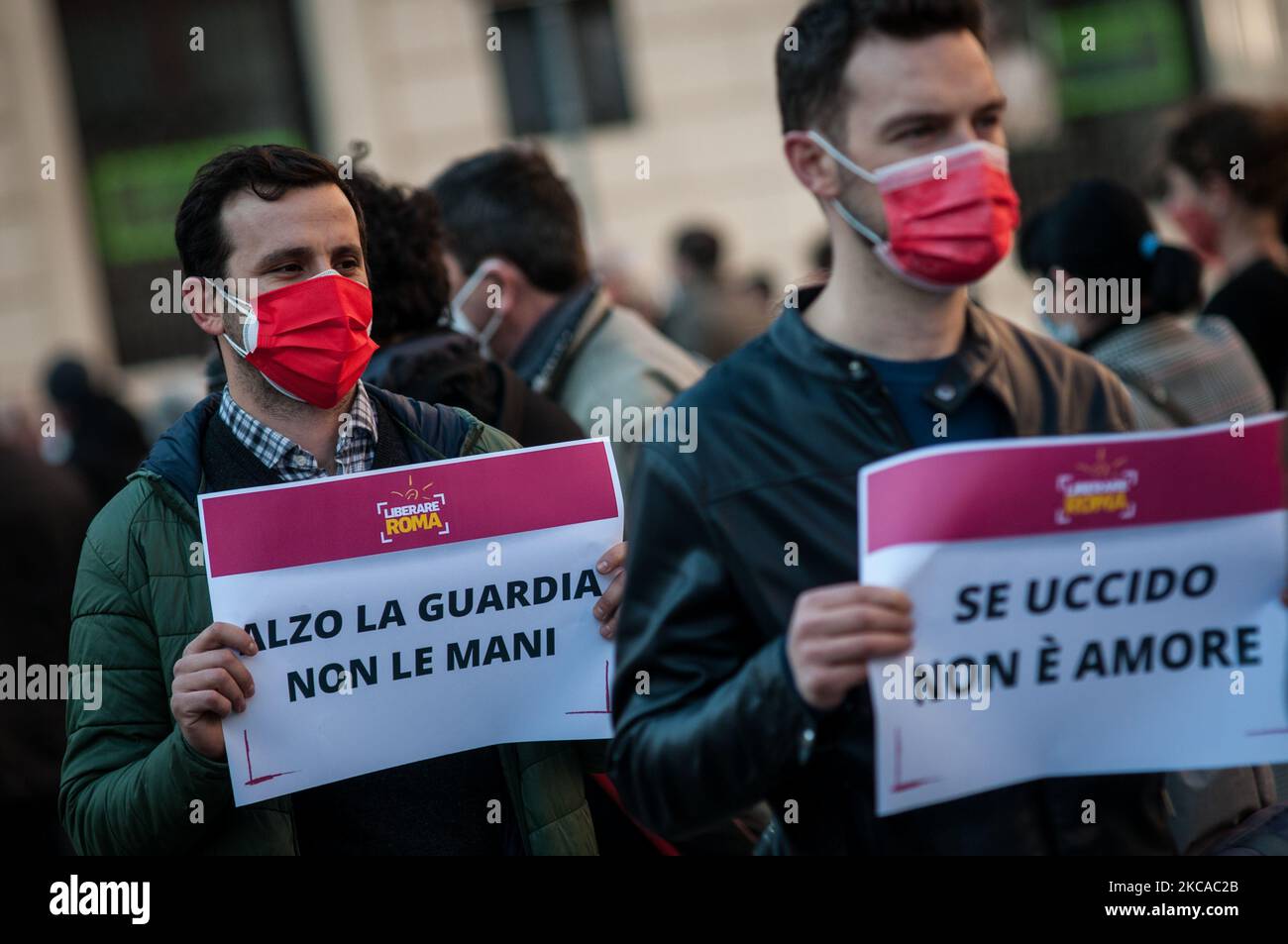 Men belonging to the city coordination 'Liberare Roma', wearing red masks as a distinctive symbol, participate in a flash mob to demonstrate against male violence against women, on March 04, 2021 in Piazza San Silvestro in the center of Rome. The men of 'Liberare Roma' protested against the increase in violence against women after the pandemic and subsequent lockouts, wearing red masks on March 4 2021 in Rome, Italy. (Photo by Andrea Ronchini/NurPhoto) Stock Photo