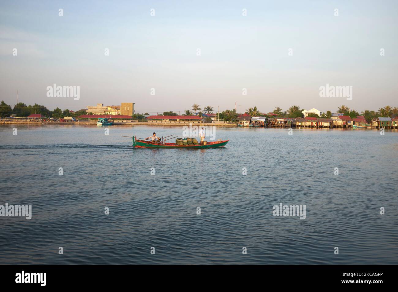 Fishing Boats leaving town at dusk to go night fishing at Kampot Cambodia Stock Photo