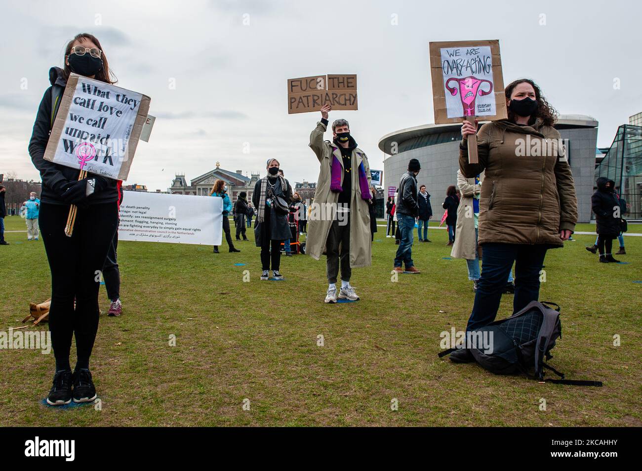 People are seen holding feminist placards while keeping social distance ...