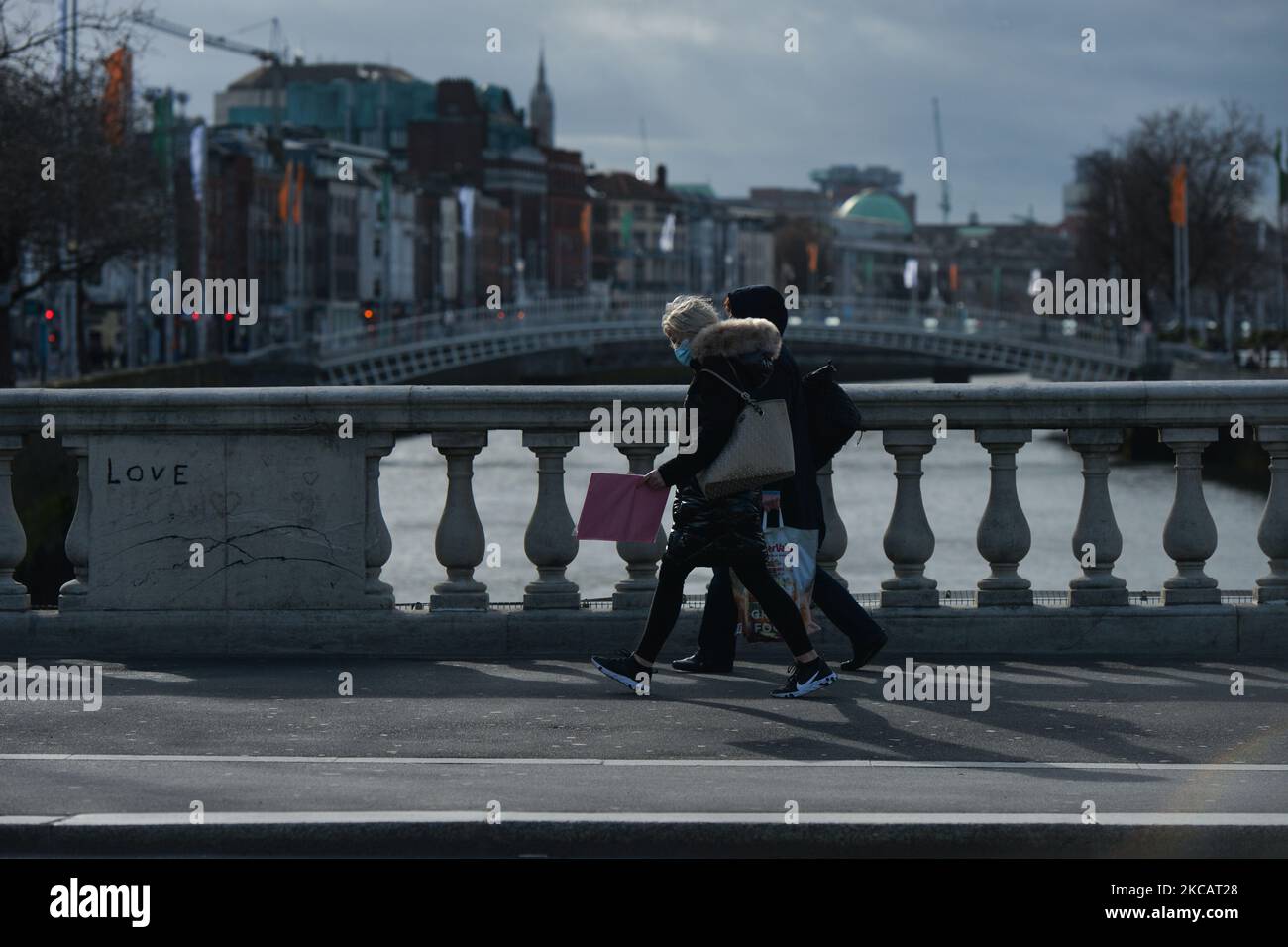 People wearing face masks walking on O'Connell Bridge in Dublin's city