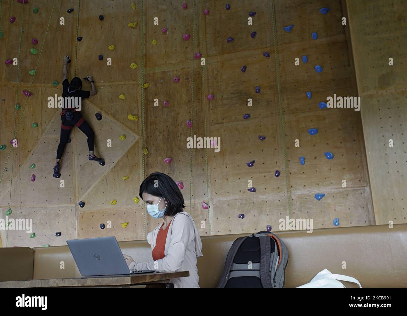 A climber climbs on the artificial wall during a training session at