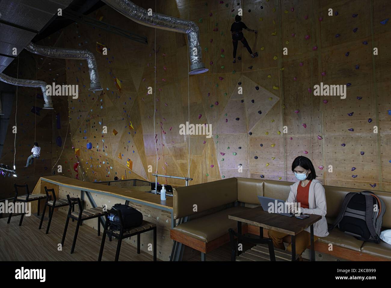 A climber climbs on the artificial wall during a training session at