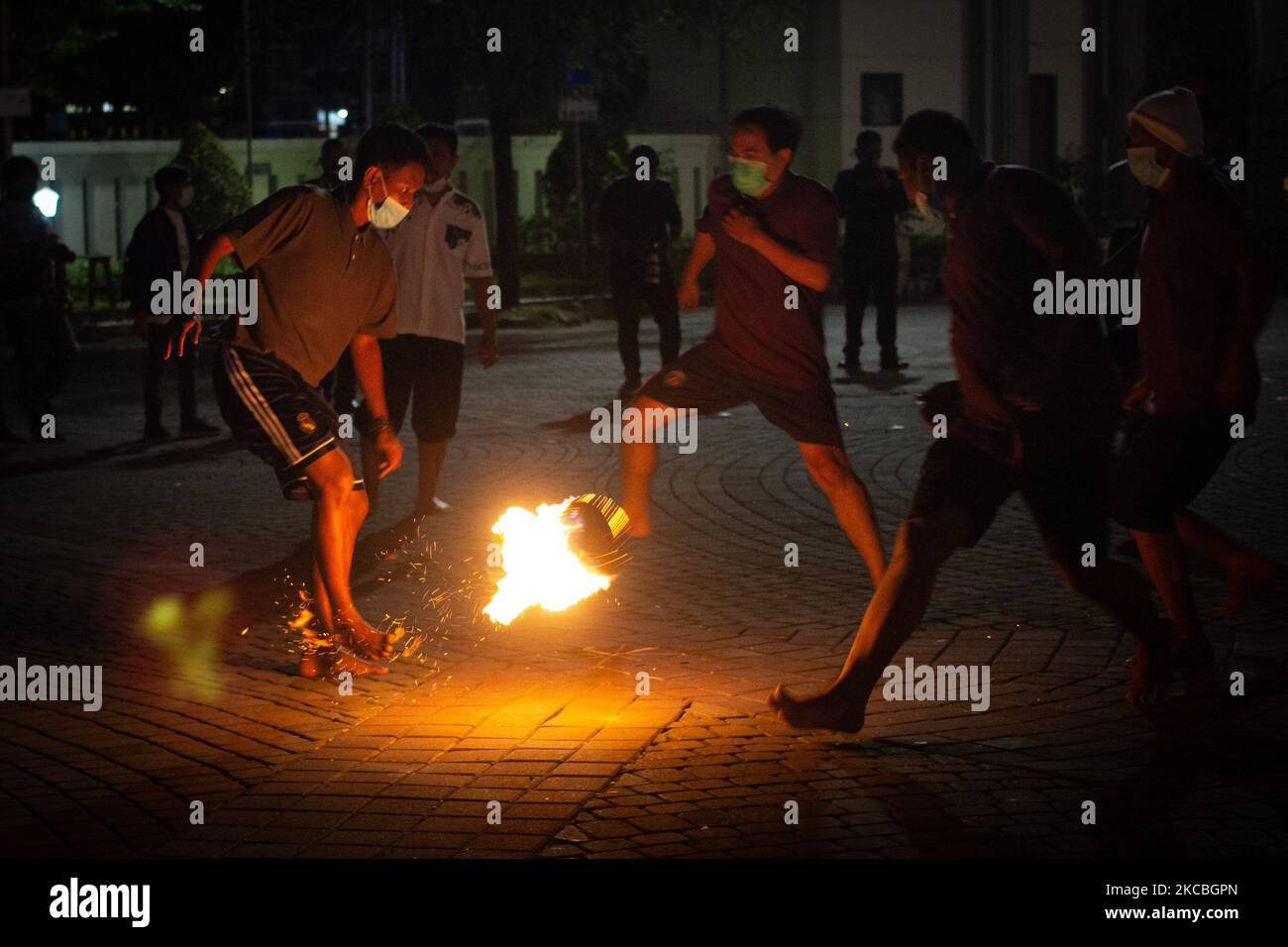 Indonesian muslims play fire football, a game played with a fire ball ...