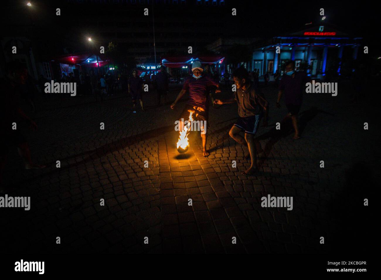Indonesian muslims play fire football, a game played with a fire ball ...