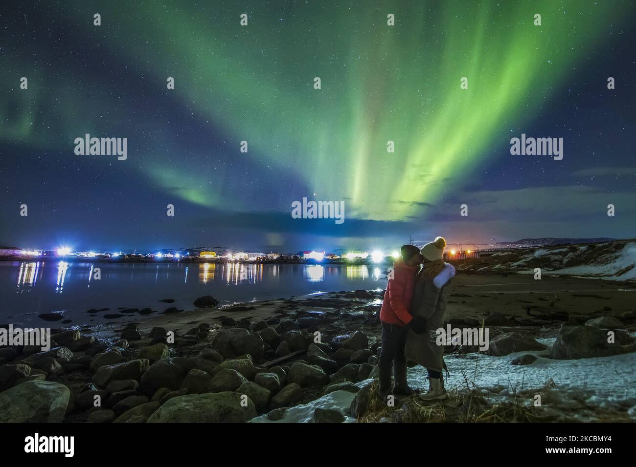 A couple of lovers kissing under an aurora borealis at Teriberka, Murmansk, Russia. Stock Photo