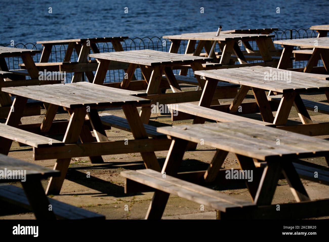 Empty tables sit out in the temporarily-closed outdoor seating area of a cafe beside the Serpentine lake in Hyde Park in London, England, on March 29, 2021. Lockdown restrictions were eased across England today, with the 'stay home' rule ended, groups of up to six allowed to meet outside, outdoor sports restarted and weddings with up to six people attending permitted to go ahead. Shops, hospitality and leisure businesses remain closed however, with the next relaxation of restrictions not due until April 12 at the earliest. Today's easing has meanwhile coincided with the first of a three-day 'm Stock Photo