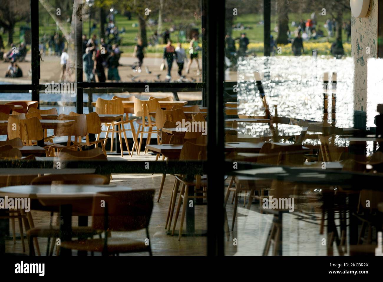 Empty tables are seen in the indoor area of a temporarily-closed cafe beside the Serpentine lake in Hyde Park in London, England, on March 29, 2021. Lockdown restrictions were eased across England today, with the 'stay home' rule ended, groups of up to six allowed to meet outside, outdoor sports restarted and weddings with up to six people attending permitted to go ahead. Shops, hospitality and leisure businesses remain closed however, with the next relaxation of restrictions not due until April 12 at the earliest. Today's easing has meanwhile coincided with the first of a three-day 'mini-heat Stock Photo