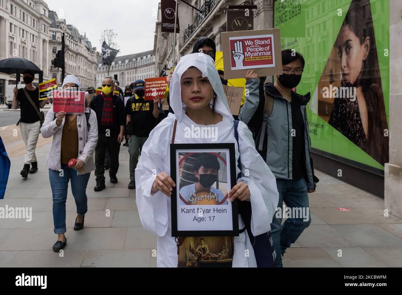 LONDON, UNITED KINGDOM - MARCH 31, 2021: Demonstrator holds a picture of a killed civilian during a march through central London to the Chinese Embassy in a protest against the military coup and killing of civilians during pro-democracy protests in Myanmar, on 31 March, 2021 in London, England. Since the military coup on 1 February, more than 520 people, including children, have been killed by security forces, in a crackdown on protesters demanding the reinstatement of the democratically elected civilian government and release of imprisoned leaders Aung San Suu Kyi and U Win Myint. (Photo by W Stock Photo
