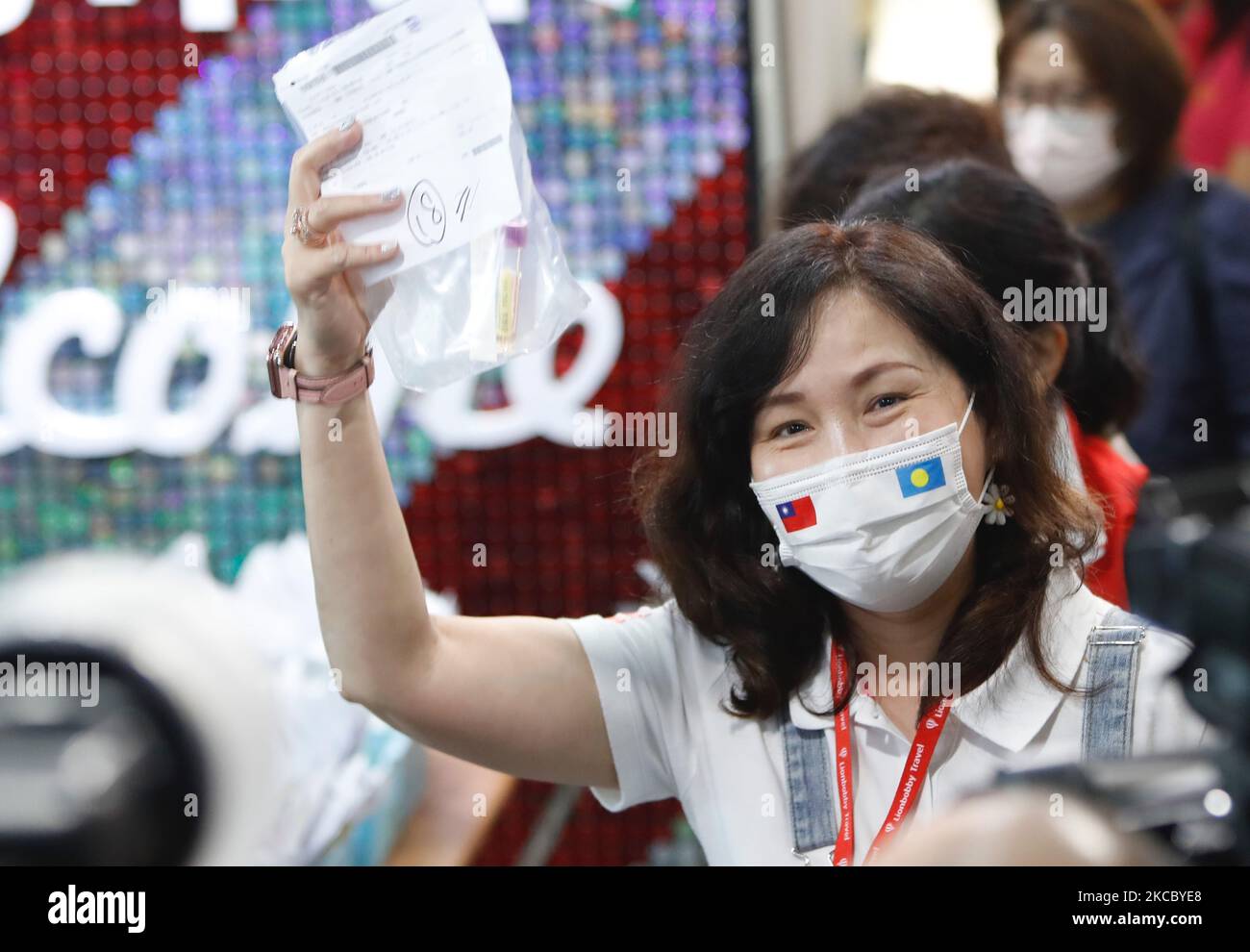 A traveler flying to Palau collects a specimen collection container at the airport near Taipei on April 1, 2021, as Taiwanese tourists headed to Palau under the first travel bubble in Indo-Pacific Asia. (Photo by Ceng Shou Yi/NurPhoto) Stock Photo