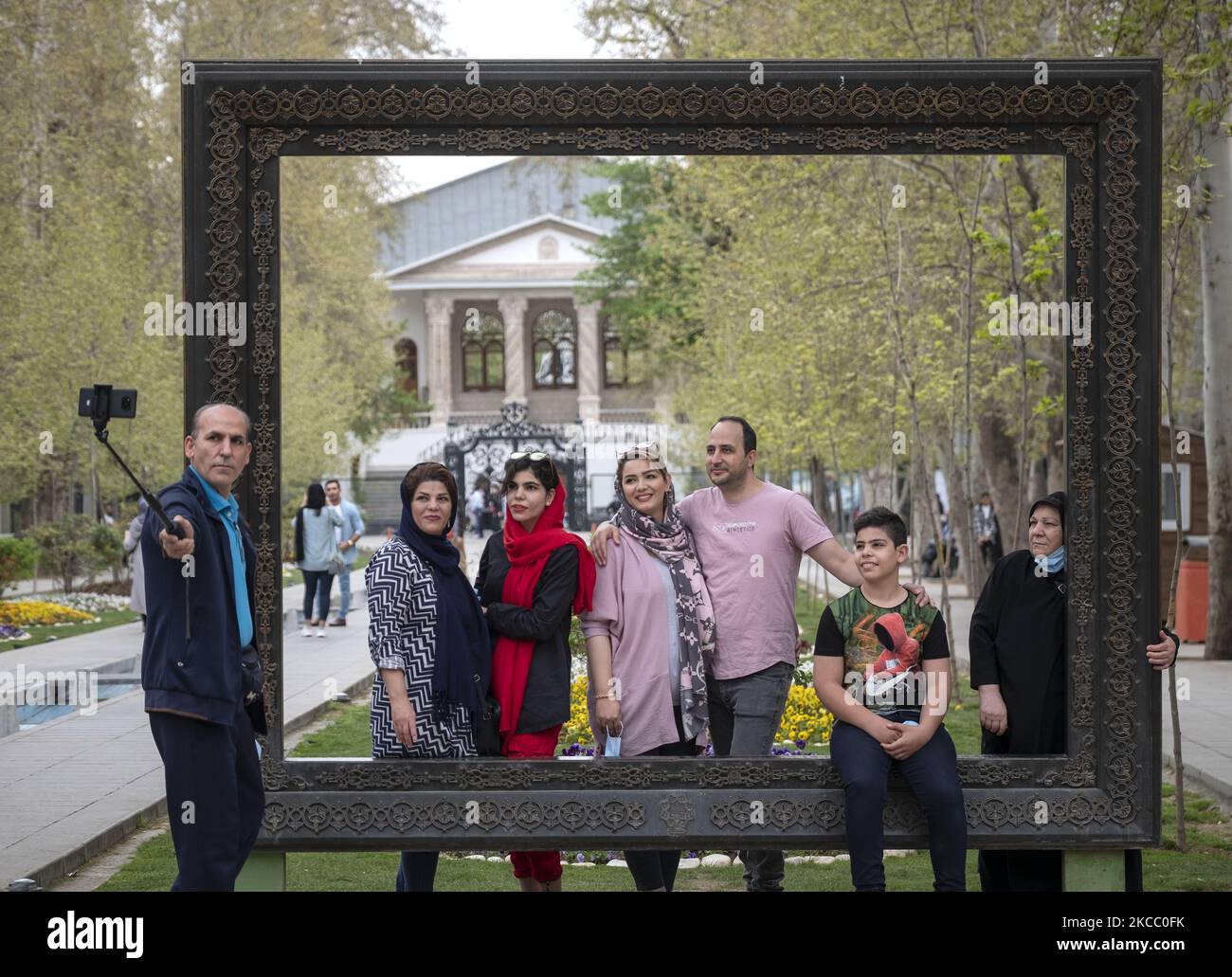 An Iranian family who none of them wearing protective face mask, take a selfie as they stand out of the Cinema Museum in northern Tehran during the day of Sizdah Bedar, also known as Nature’s Day, on April 2, 2021. Sizdah Bedar also known as Nature’s Day is an Iranian festival held annually on the thirteenth day of Farvardin (the first month of the Iranian calendar) which people spend time outdoor and mark the end of the Nowruz holidays in Iran. But the Iranian Government closed the parks and asked people to stay at their homes for protecting themselves and the others against the new coronavir Stock Photo