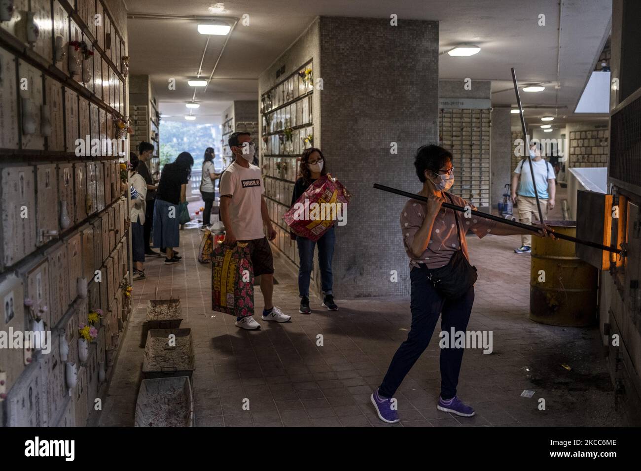 A women burns paper offering at a columbarium during the Ching Ming