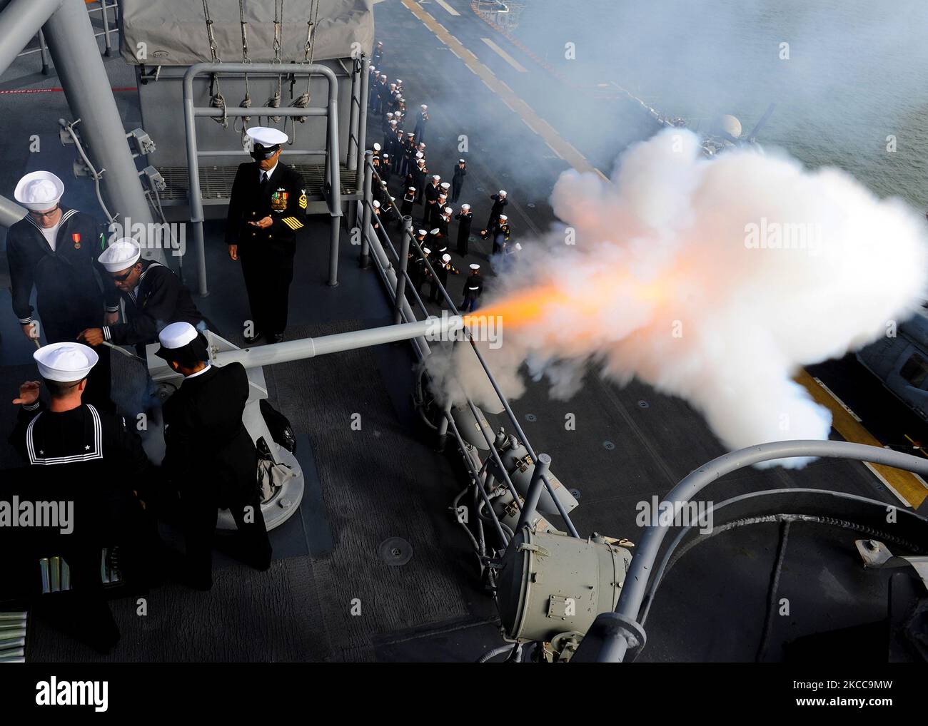 Sailors fire a 40mm saluting battery aboard the amphibious assault ship USS America. Stock Photo
