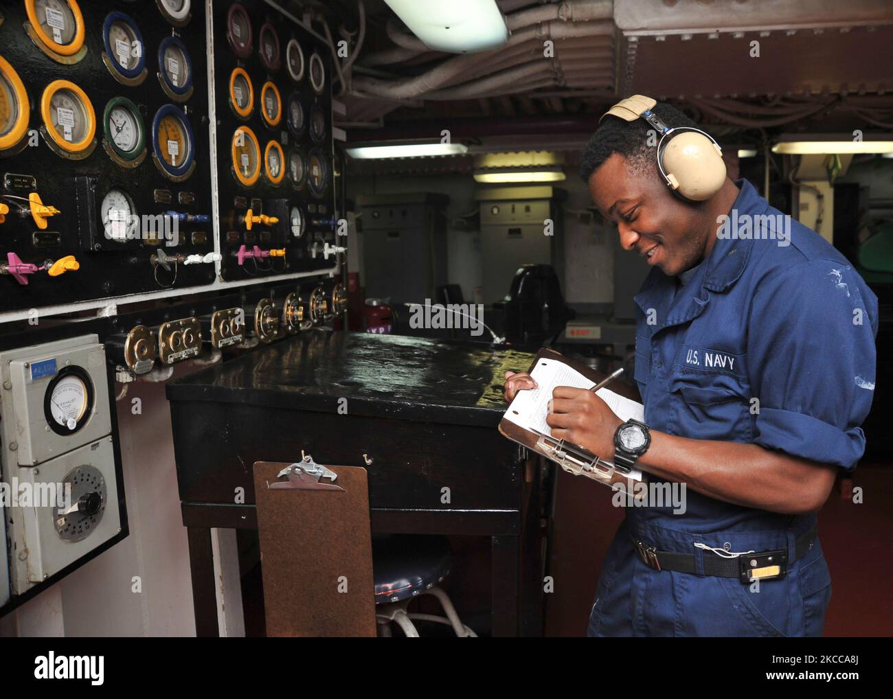 Machinistâ€™s Mate Fireman conducts a maintenance check on a diesel generator. Stock Photo