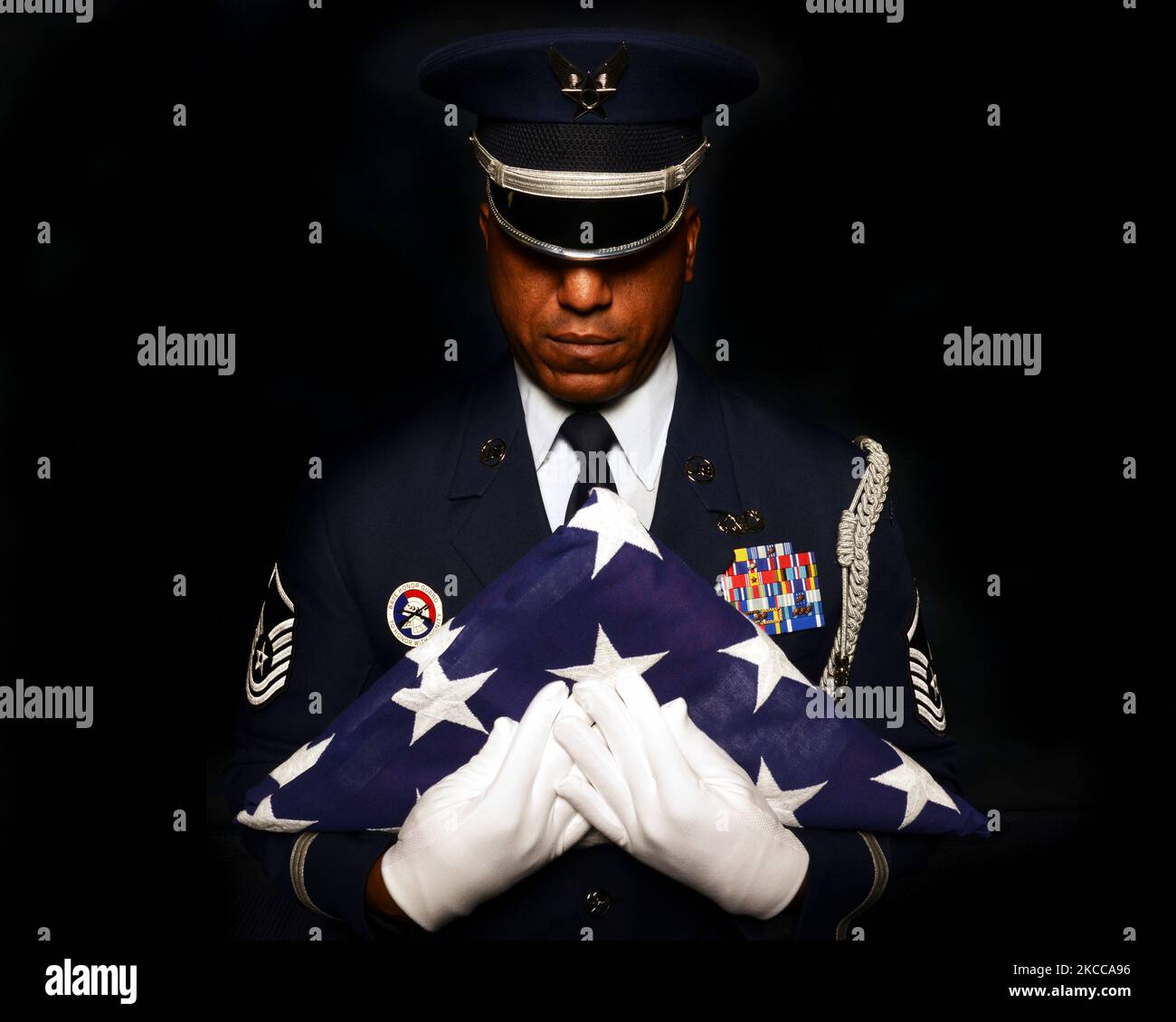 U.S. Air Force Honor Guard clutches an American Flag to his chest. Stock Photo