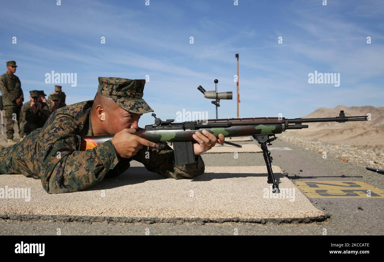 U.S. Marine aims an M14 service rifle down range. Stock Photo