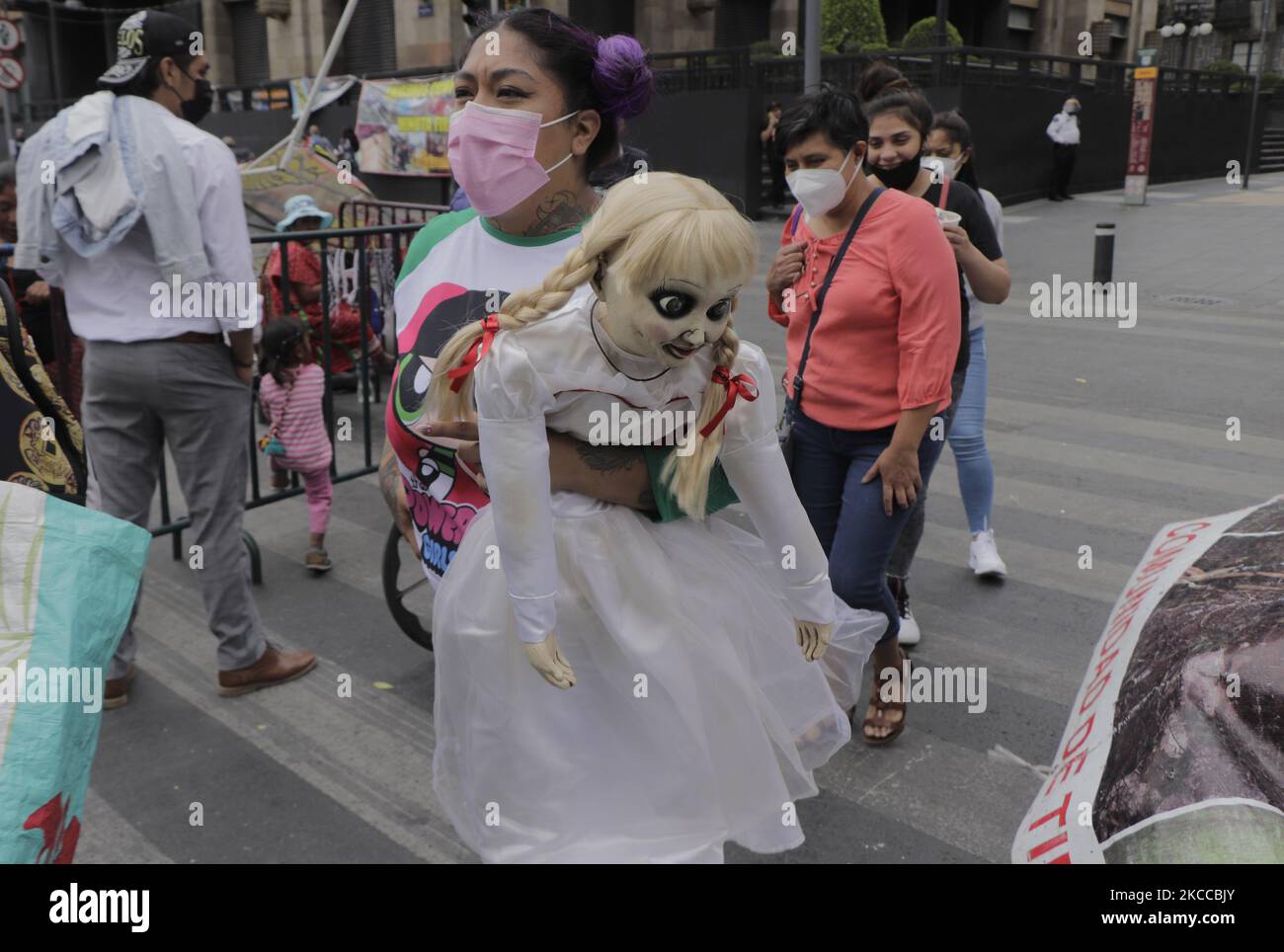 A woman carries a doll of the horror movie character Annabelle in the main square of Mexico City's Zócalo, Mexico, on April 6, 2021 during the COVID-19 health emergency and the orange epidemiological traffic light in the capital. Mexico is the thirteenth most infected country in the world and has the third highest number of deaths due to the pandemic, behind the United States and Brazil, according to Johns Hopkins University. (Photo by Gerardo Vieyra/NurPhoto) Stock Photo