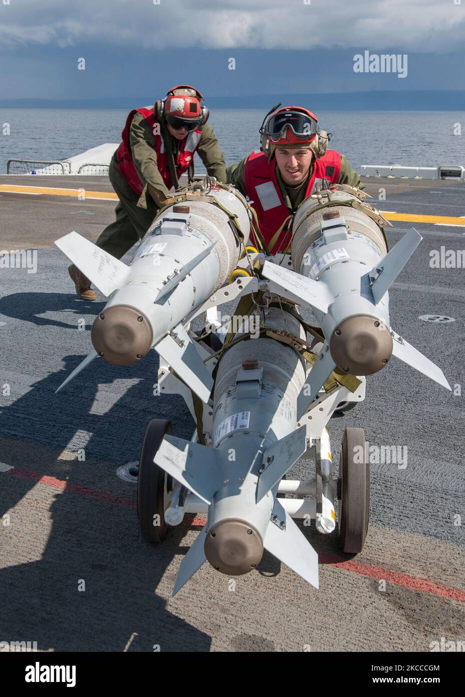 Airmen position a rack of high-explosive guided bomb units. Stock Photo