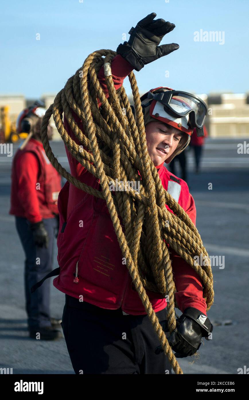 Aviation Boatswain's Mate coils line on the flight deck of USS Harry S. Truman. Stock Photo