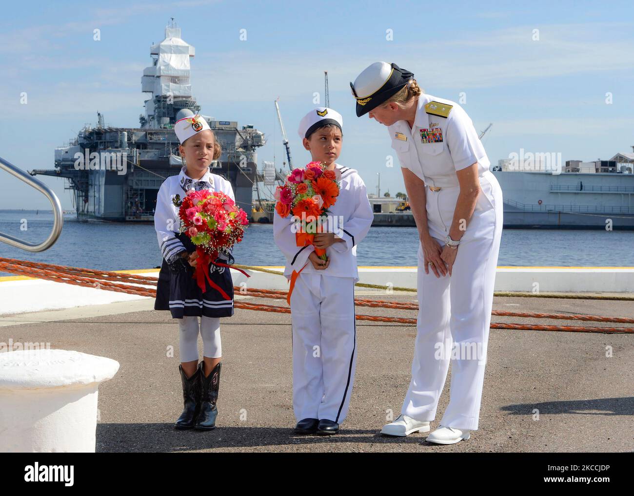 U.S. Navy Commander speaks with two ceremonial children. Stock Photo