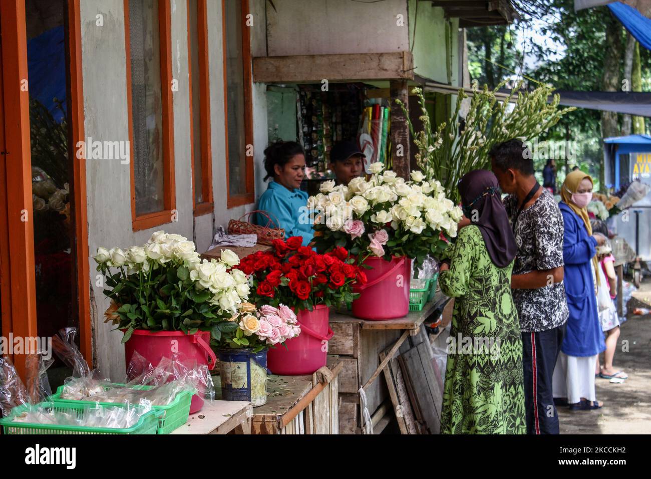 A woman sells flowers waits for a customers at Cibarunai Tomb on 12