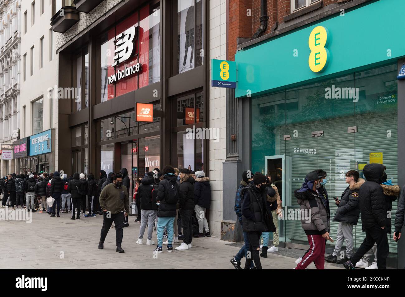 LONDON, UNITED KINGDOM - APRIL 12, 2021: Shoppers queue outside Foot Locker store on Oxford Street as shops open their premises to customers after being closed for over three months under coronavirus lockdown, on 12 April, 2021 in London, England. From today the next stage of lifting lockdown restrictions goes ahead with pubs and restaurants allowed to serve food and drinks outdoors, opening of non-essential shops, hairdressers, beauty salons and gyms in England. (Photo by WIktor Szymanowicz/NurPhoto) Stock Photo