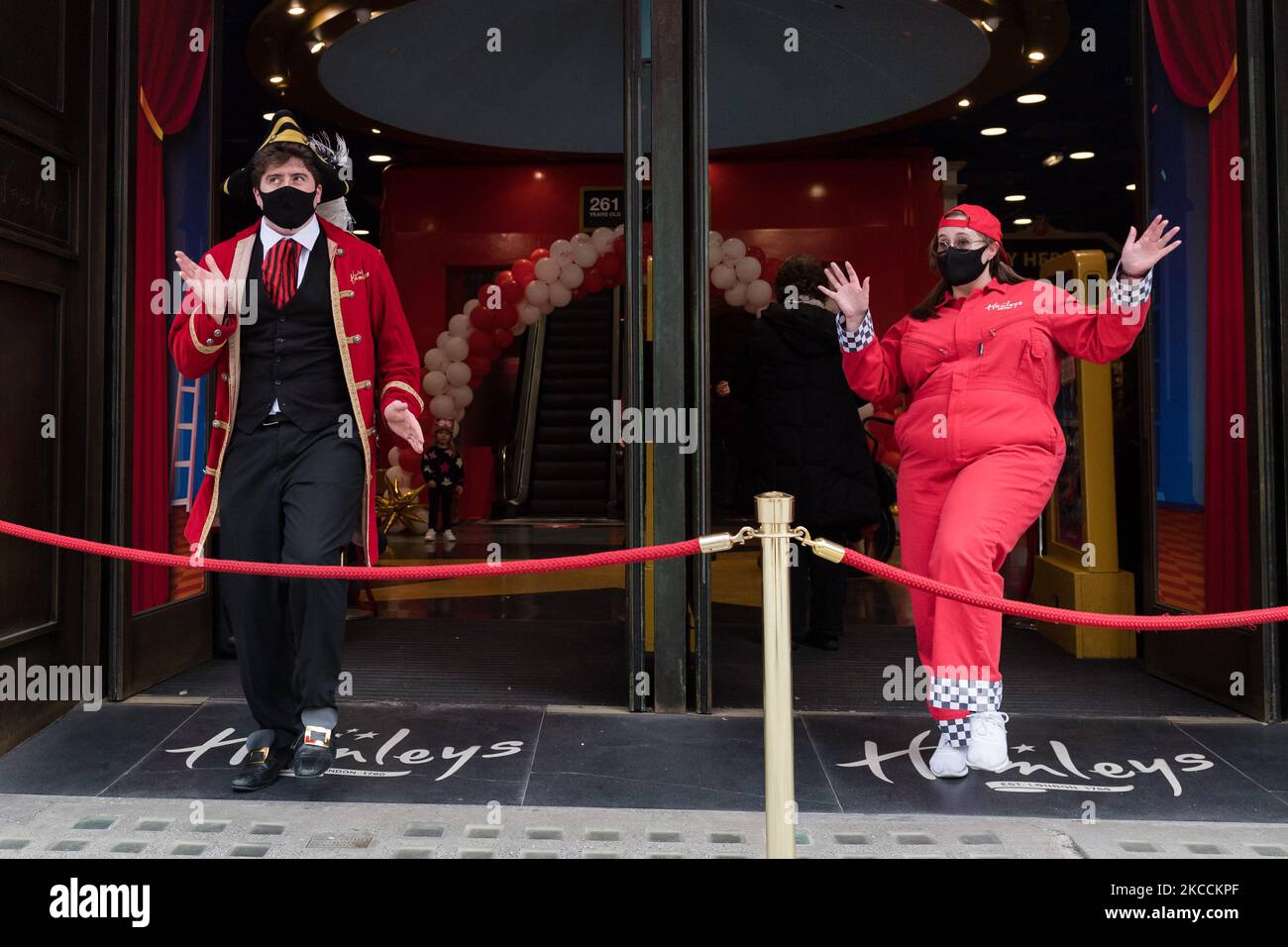 LONDON, UNITED KINGDOM - APRIL 12, 2021: Staff wearing fancy dress dance outside Hamleys toy store on Regent Street as shops open their premises to customers after being closed for over three months under coronavirus lockdown, on 12 April, 2021 in London, England. From today the next stage of lifting lockdown restrictions goes ahead with pubs and restaurants allowed to serve food and drinks outdoors, opening of non-essential shops, hairdressers, beauty salons and gyms in England. (Photo by WIktor Szymanowicz/NurPhoto) Stock Photo