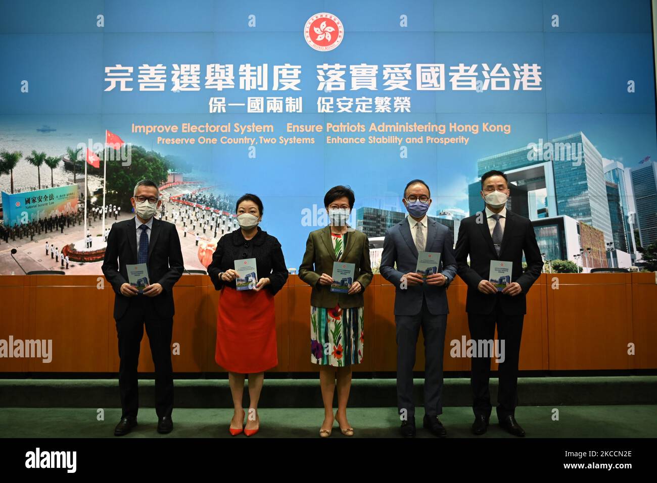 From Left to Right Ms Llewellyn Mui, Acting Officer(Special Duties), Ms Teresa Cheng, Secretary for Justice, Mrs Carrie Lam, Chief Executive of Hong Kong, Mr Eric Tsang, Secretary for constitution and mainland affairs, Mr Roy Tang, permanent secretary for Constitutional and Mainland affairs hols up booklet during a press conference on 'Improving Electoral System' in Hong Kong, China, on April 13, 2021. The government is formally proposing to make it a crime for people to urge others to cast blank or spoiled ballots, or not vote at all, as it unveiled a host of bills to amend local laws in line Stock Photo