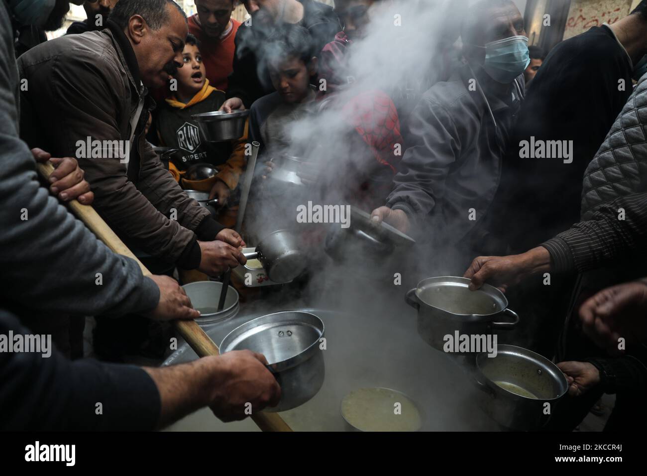 Palestinians gather to get soup offered for free during the Muslim fasting month of Ramadan, in Gaza City on April 13, 2021. (Photo by Majdi Fathi/NurPhoto) Stock Photo