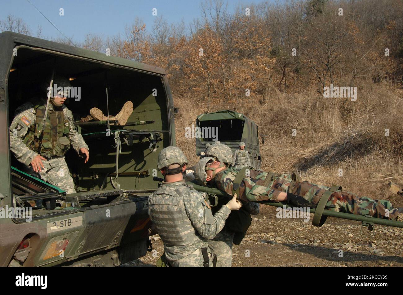U.S. Army combat medics load a simulated injured soldier into an ambulance. Stock Photo