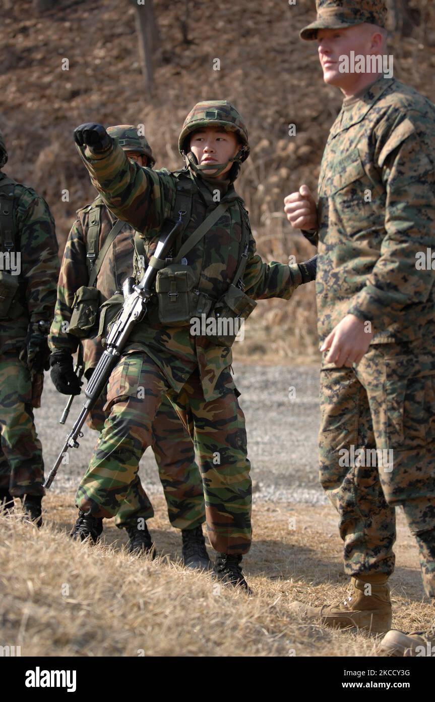 U.S. Marine instructs a Republic of Korea Marine on the proper way to