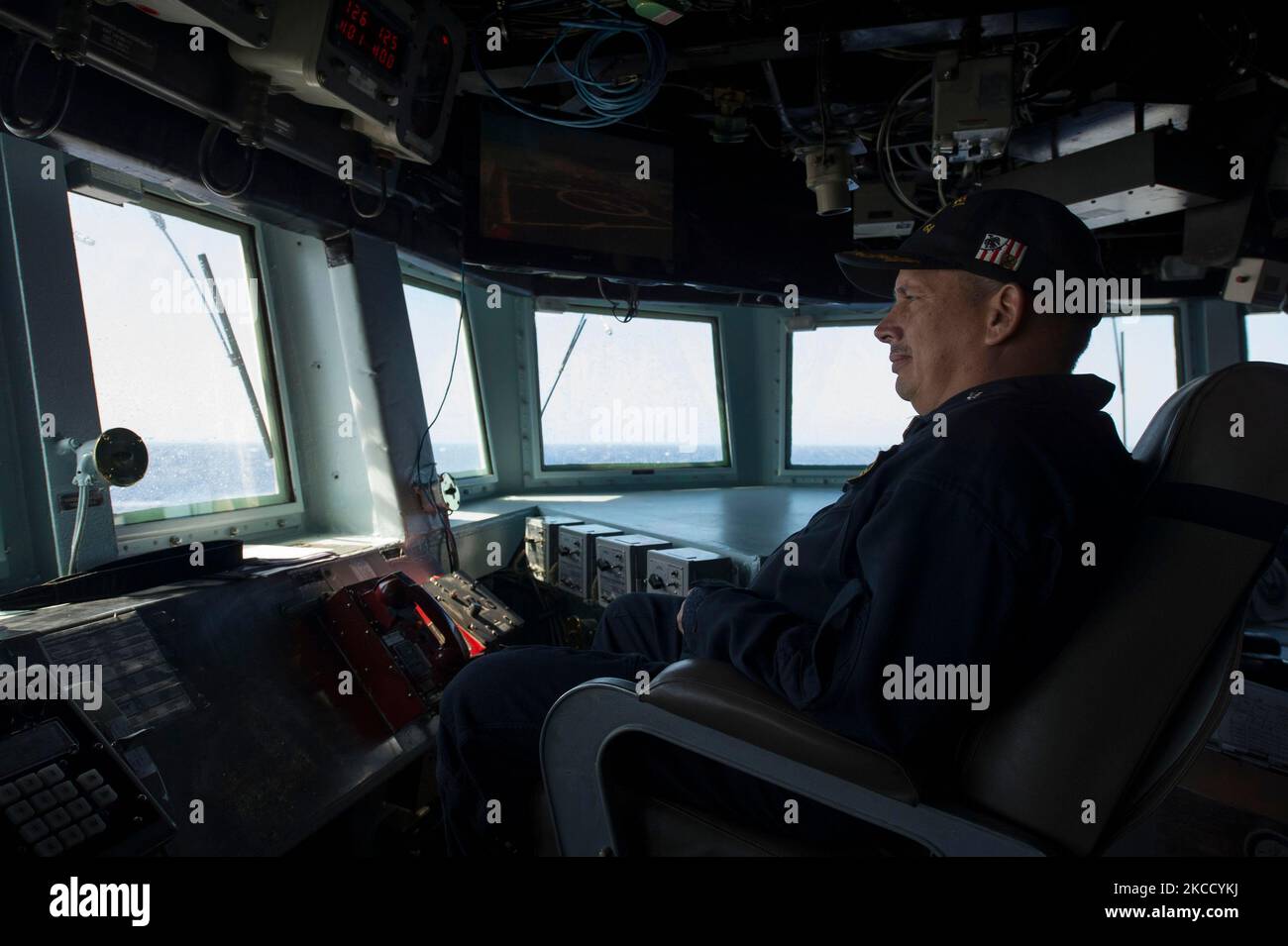Commanding officer of guided missile destroyer USS Carney sits in the pilot house. Stock Photo