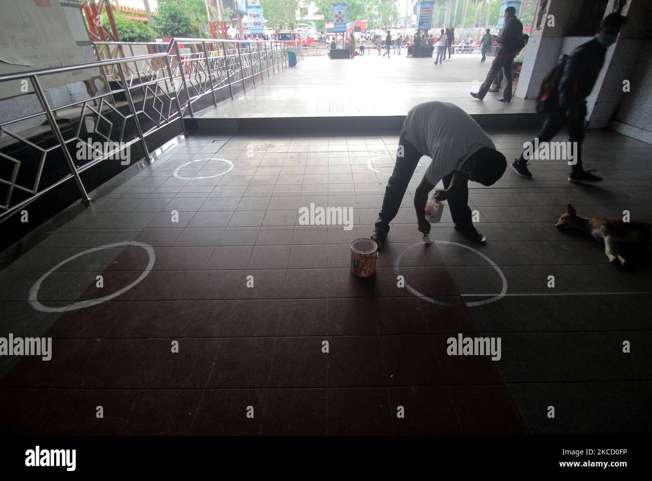 A worker marks circles for maintaining social distance at the city railway station due to Covid-19 coronavirus again spike in the eastern Indian state Odisha's capital city Bhubaneswar on April 18, 2021. (Photo by STR/NurPhoto) Stock Photo