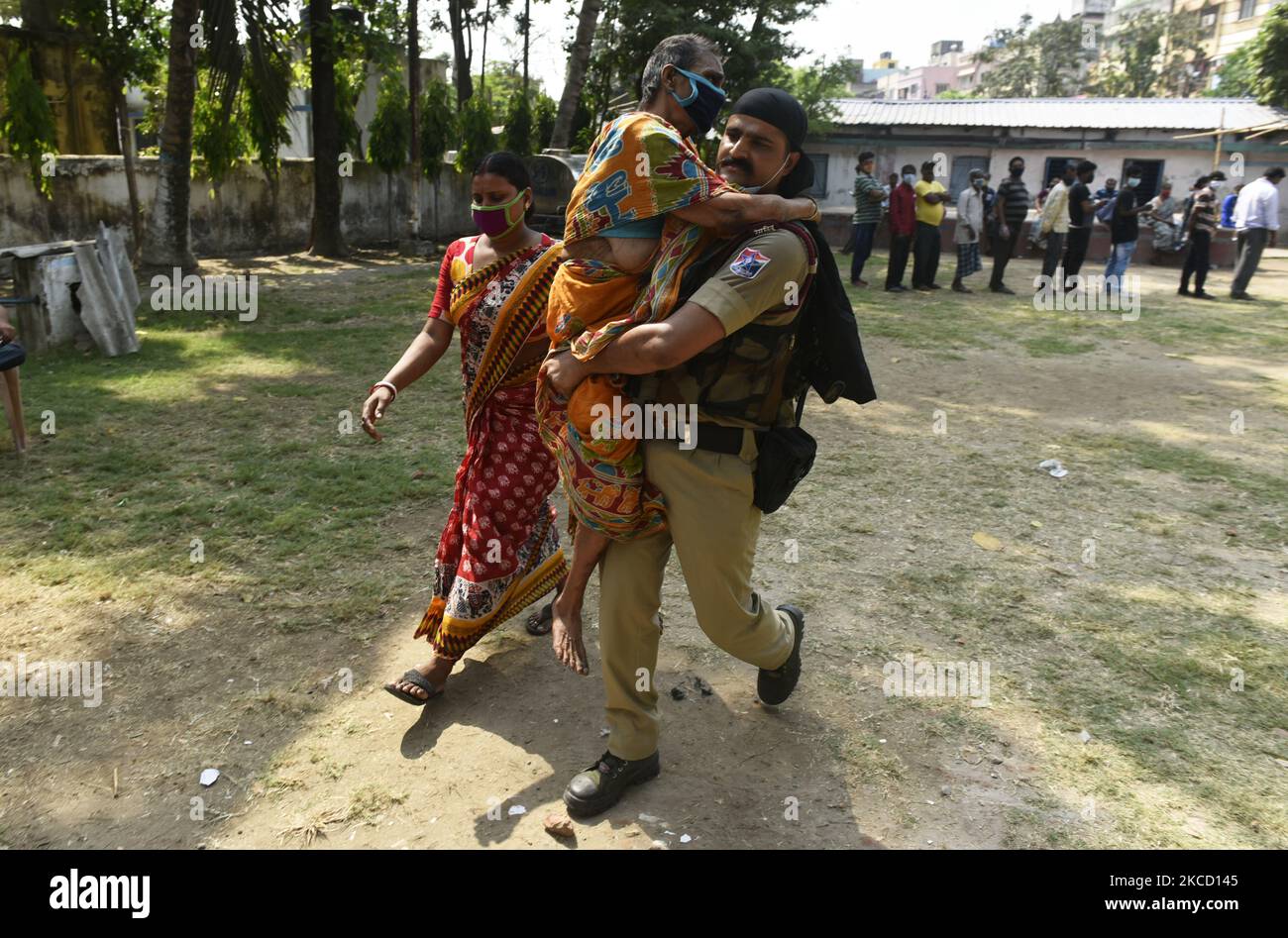 An elderly voter is assisted by a paramilitary personnel after casting her vote at a polling station during the Fifth phase West Bengal assembly election in Kolkata, India, 17 April, 2021. Election Commission has decided to ban rallies, public meeting and streets play in poll-bound West Bengal from 7 pm to 10 am due to the Covid-19 spike in India according to an Indian media report. (Photo by Indranil Aditya/NurPhoto) Stock Photo