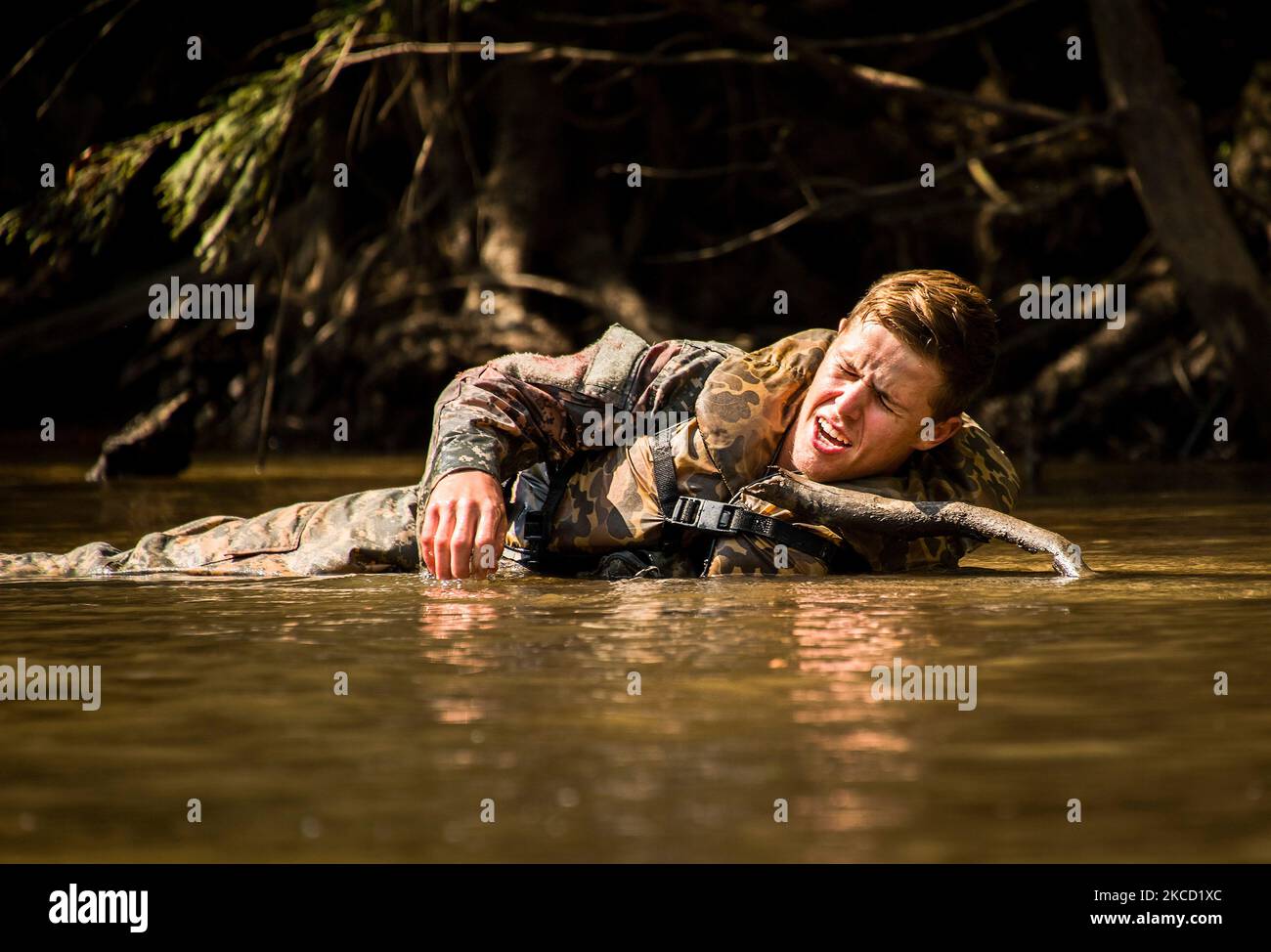 A simulated wounded soldier yells for help whily lying in the river. Stock Photo