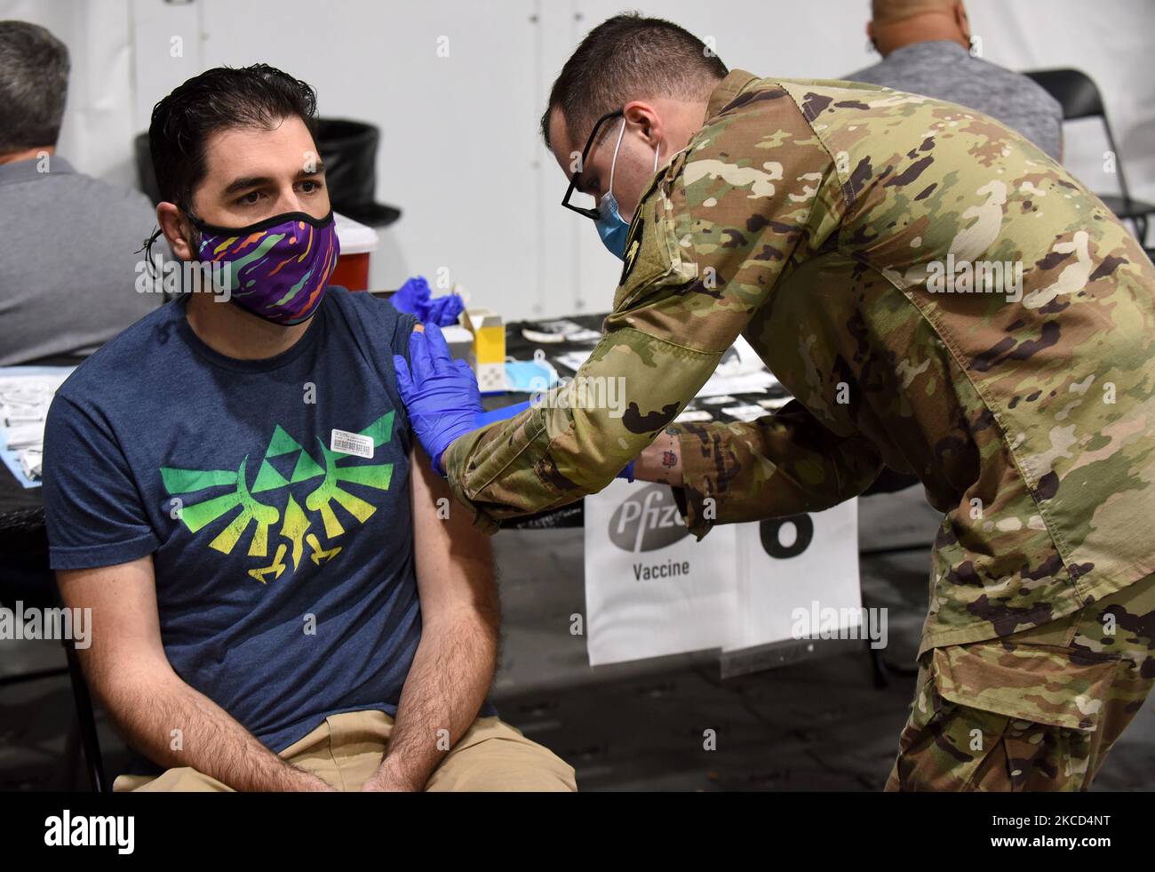 An Army medic from Fort Campbell, Kentucky gives Tim Zenkel a COVID-19 vaccine shot at a FEMA supported vaccination site at Valencia State College on April 20, 2021 in Orlando, Florida. The site, which had offered the Johnson & Johnson vaccine before the vaccine pause, today began administering up to 3,000 first and second doses daily of the Pfizer vaccine. (Photo by Paul Hennessy/NurPhoto) Stock Photo