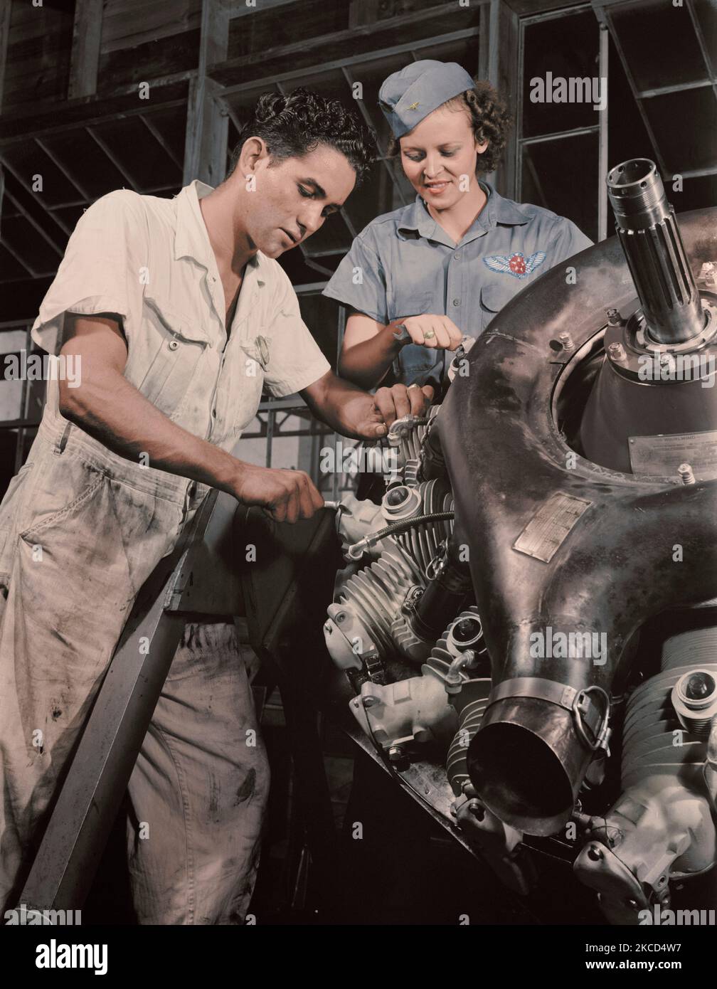 An expert mechanic shows a student the tricks of an airplane motor, 1942. Stock Photo