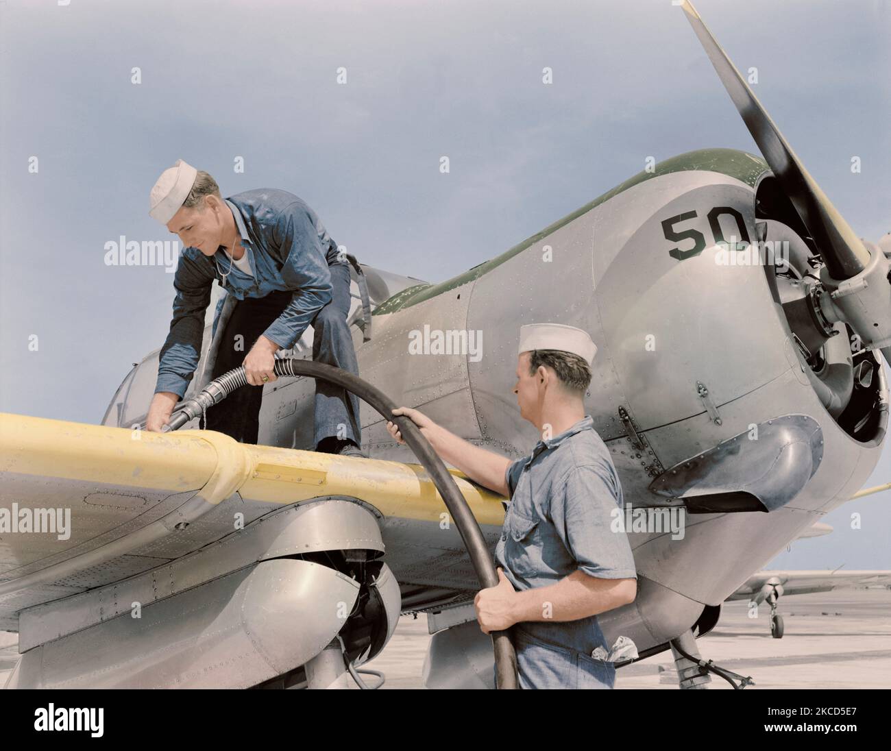 Sailor mechanics refueling an SNC advanced training plane, 1942. Stock Photo