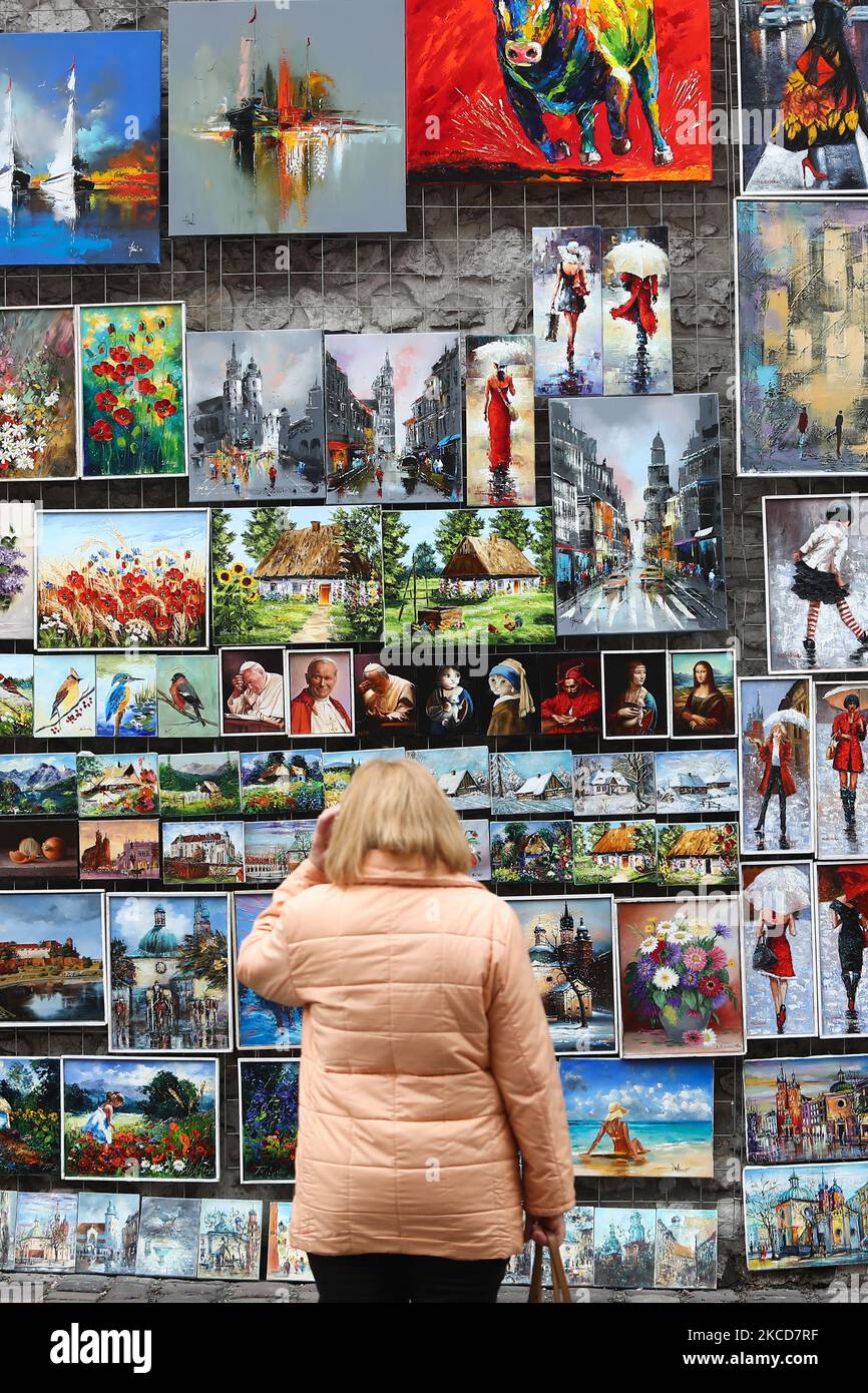 A woman looks at the paintings on the street gallery in Krakow, Poland on April 18, 2021. (Photo by Jakub Porzycki/NurPhoto) Stock Photo