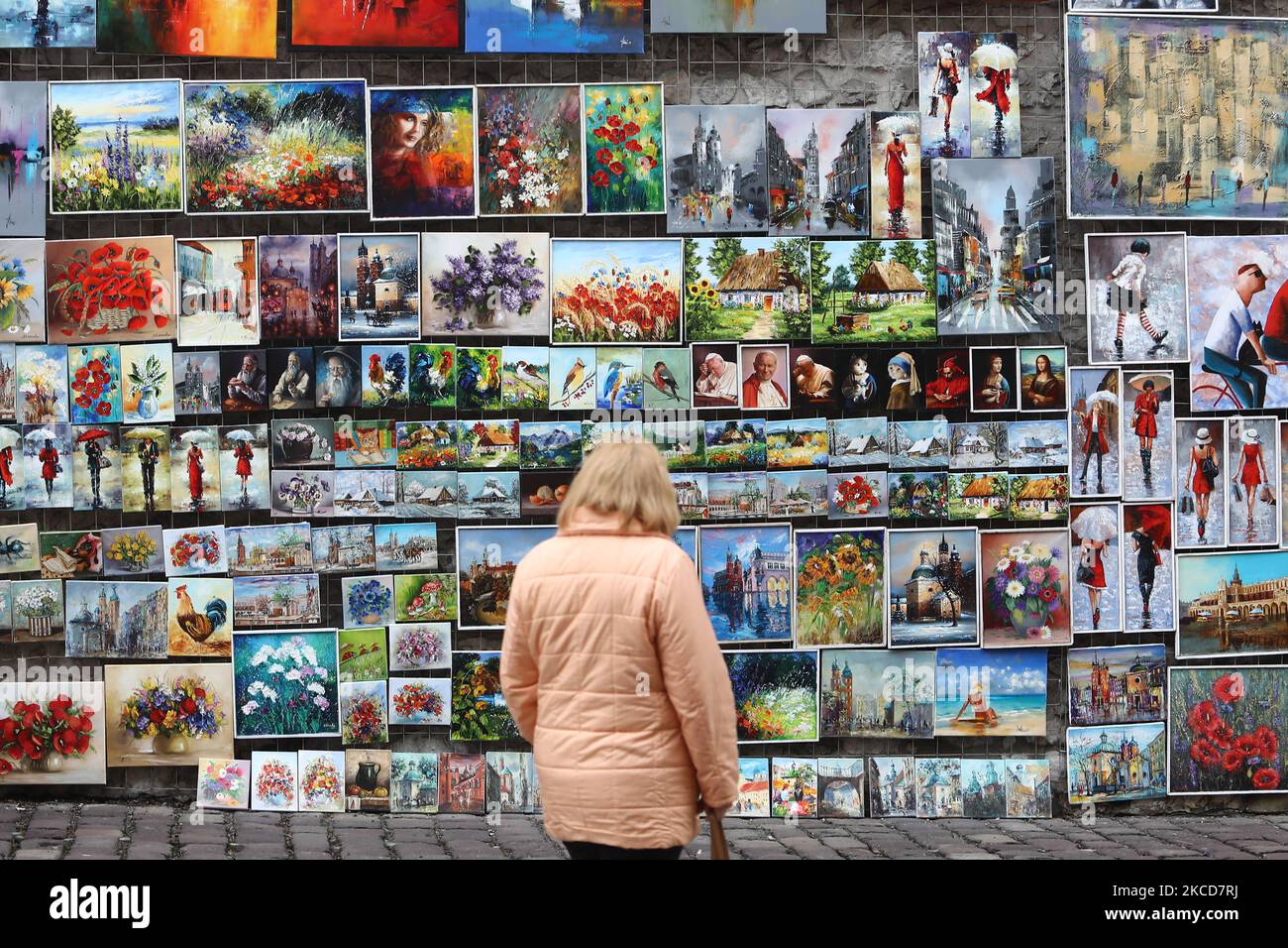 A woman looks at the paintings on the street gallery in Krakow, Poland on April 18, 2021. (Photo by Jakub Porzycki/NurPhoto) Stock Photo