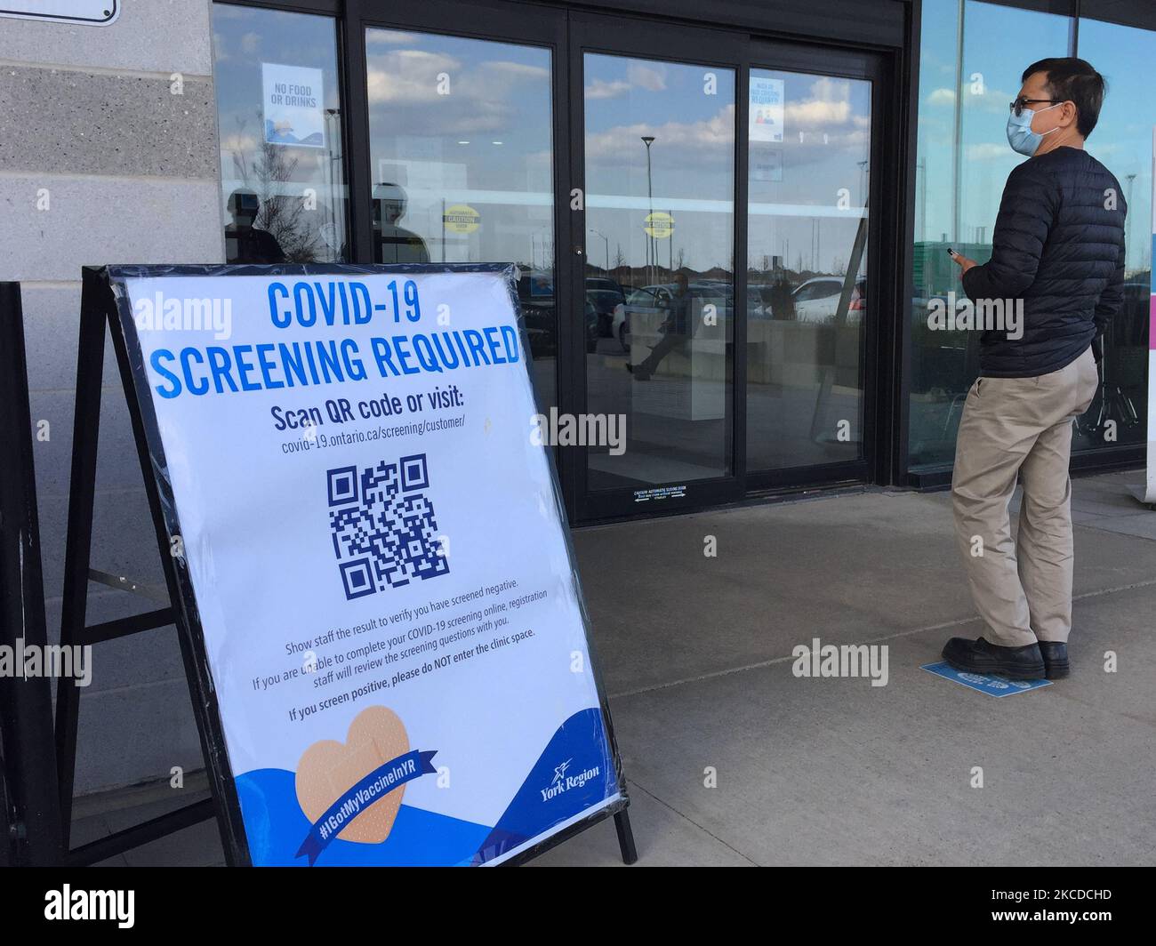 Man waits to enter a COVID19 mass vaccination centre in York Region