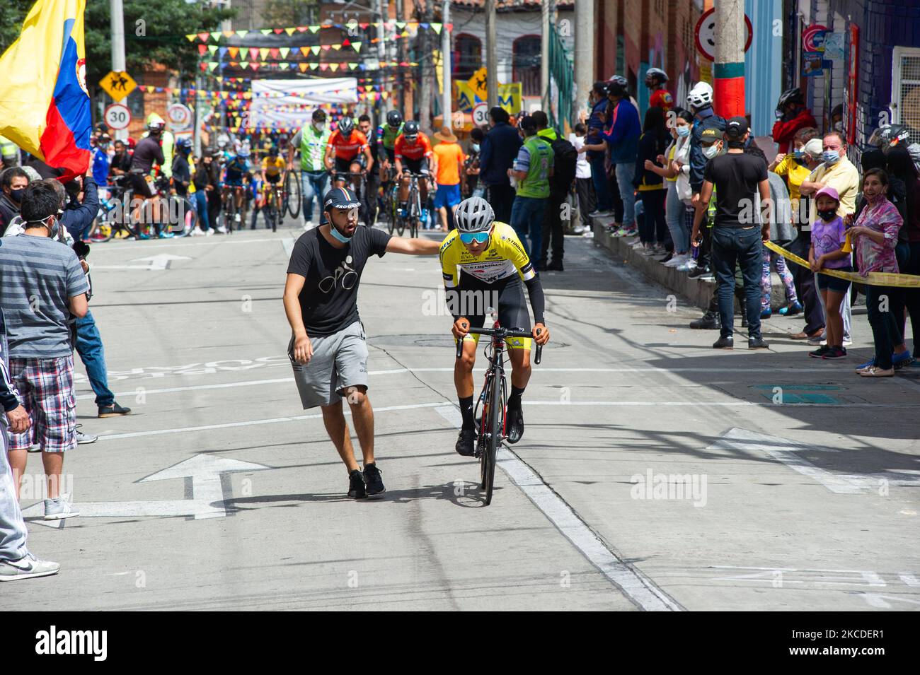 A viewer of the 2021 Vuelta a Colombia final stage circuit in Bogota, pushes a ciclyst to help him climb faster the stage during the climb of the Perseverancia neigborhood in Bogota, Colombia on April 25, 2021 won by the Colombian ciclyst Tito Hernandez. (Photo by Sebastian Barros/NurPhoto) Stock Photo