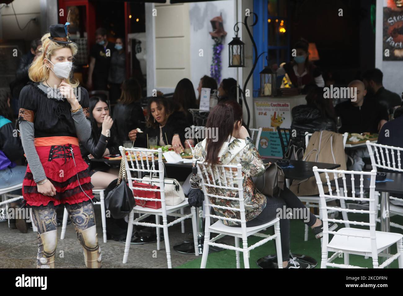 People have a drink on a bar terrace at the Navigli in downtown Milan, Italy on April 26, 2021 as bars, restaurants, cinemas and concert halls partially reopen across Italy in a boost for coronavirus-hit businesses, as parliament debates the government's 220-billion-euro ($266-billion) EU-funded recovery plan. - After months of stop-start restrictions imposed to manage its second and third waves of Covid-19, Italy hopes this latest easing will mark the start of something like a normal summer. (Photo by Mairo Cinquetti/NurPhoto) Stock Photo